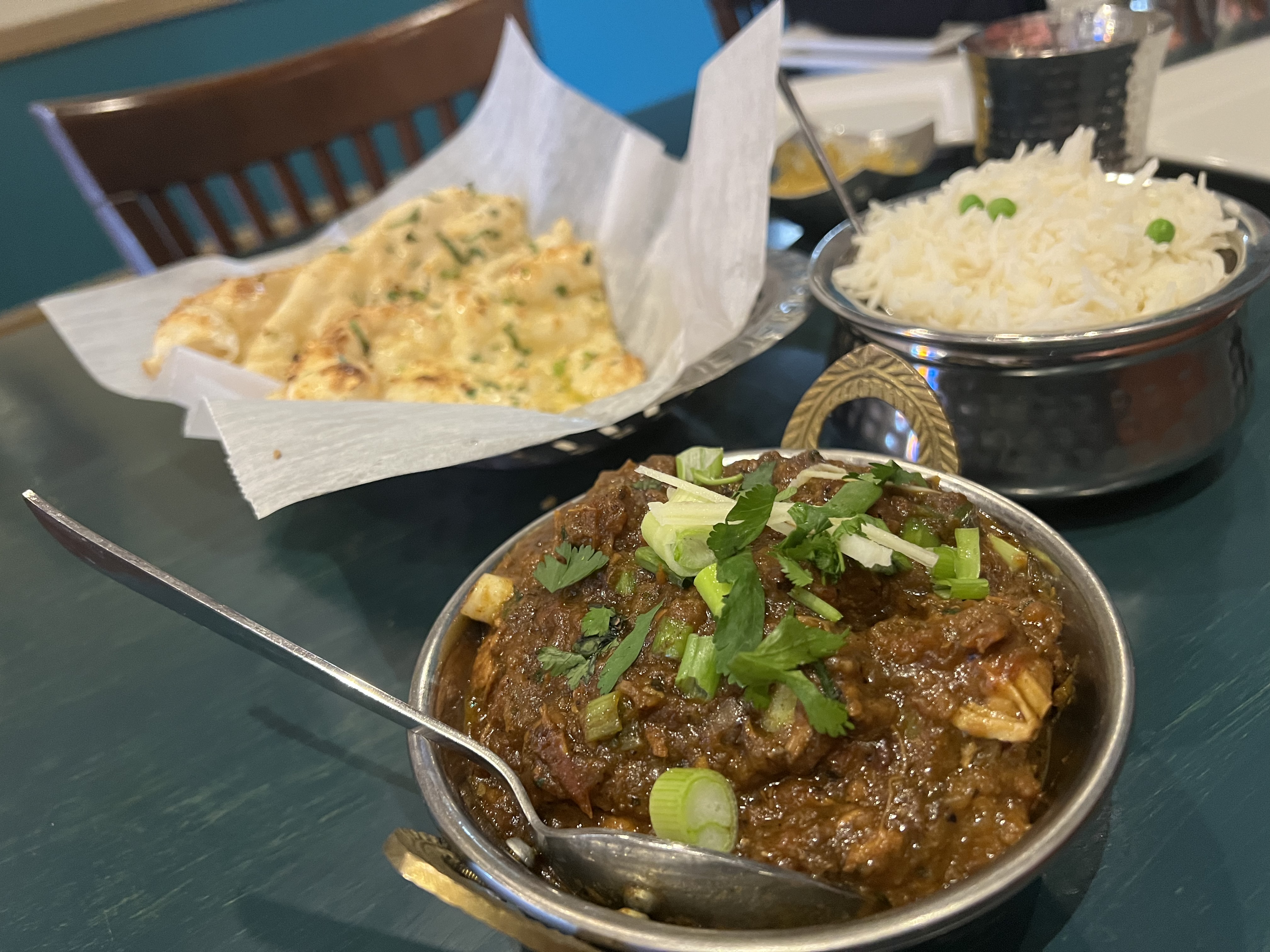 lamb curry in a copper bowl with naan