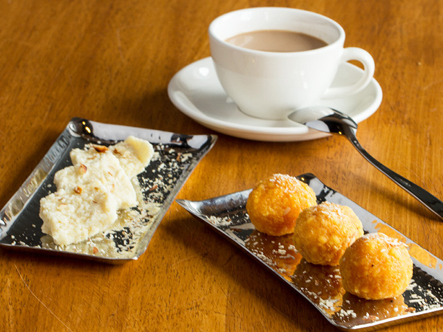 cup of masala chai with cookies and mini doughnuts